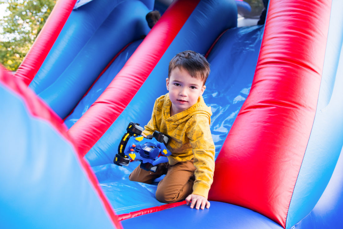 Major Martino slides down the side of the Bounce House at his Construction Zone themed birthday party