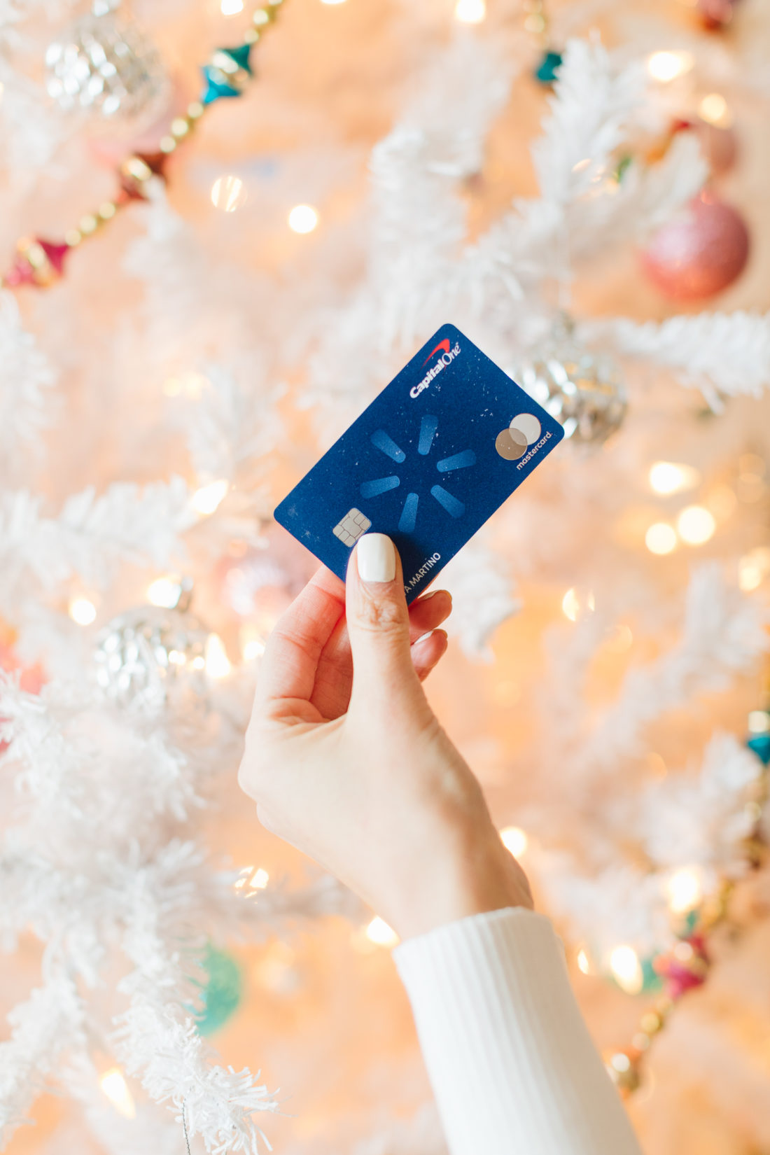 Eva Amurri holds her Capital One Walmart Rewards Credit Card by her Christmas Tree