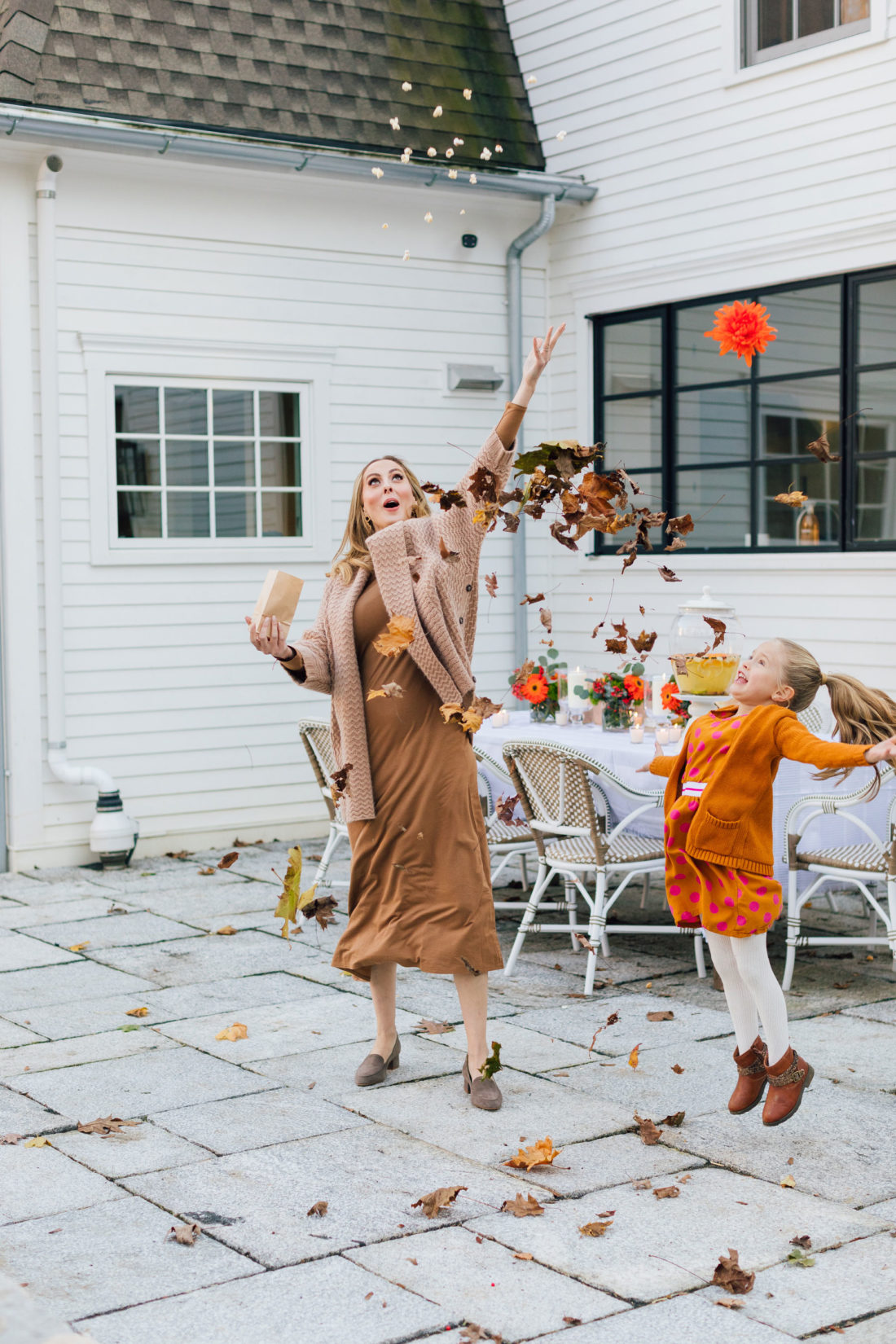 Eva Amurri and daughter Marlowe throw a pile of leaves in the air before an outdoor movie night on the back patio of her Connecticut home