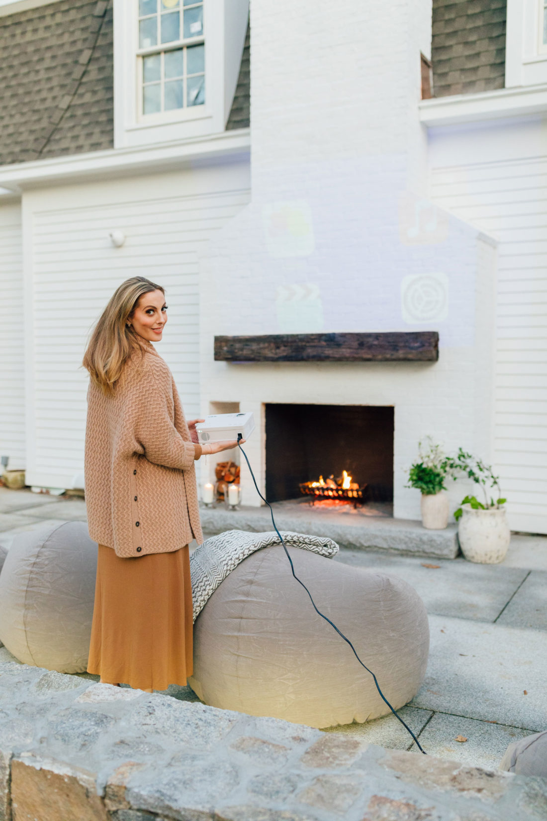 Eva Amurri holds a portable projector for an outdoor movie night on her back patio at her home in Connecticut